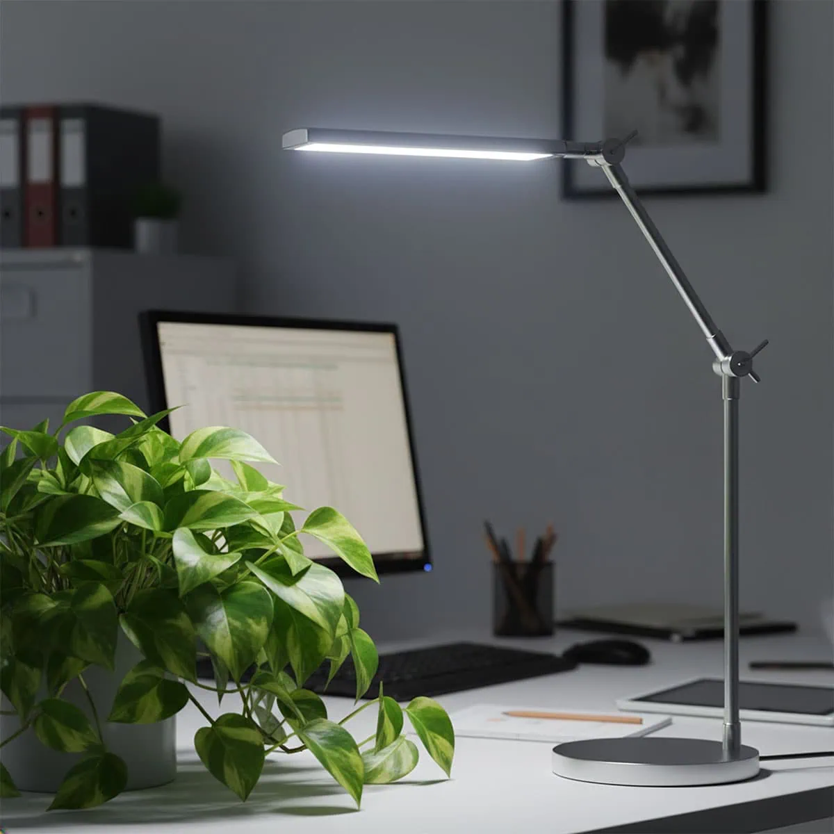 A pothos thriving on an office desk under a lamp, answering can pothos live in artificial light.